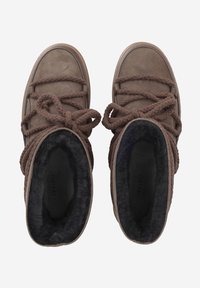 Bottes en suède marron avec des lacets en corde épaisse et texturée, et un intérieur en fourrure noire. Bout arrondi et design mi-haut, avec une semelle plate.