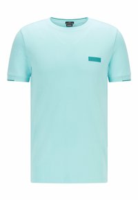 Světle modré bavlněné tričko s krátkými rukávy, kulatým výstřihem a malým embosovaným logem na levé hrudi. Hladká textura, ležérní design.