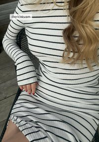 Randig ribbad klänning i vitt och svart, långa ärmar med åtsittande manschetter, textil med struktur, som når strax ovanför knäet, med en sidofåra.