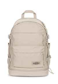 Zaino Eastpak beige dalla forma arrotondata, con spallacci regolabili, numerose tasche e una patella con il marchio. Realizzato in tessuto resistente con una superficie liscia.