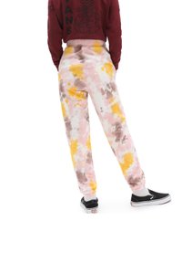 Tie-dye sweatpants i rosa, gult och brunt, med en vältränad midja och elastiska muddar. Stylade med svarta slip-on skor.