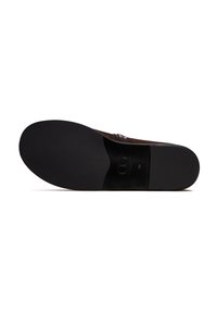 Scarpa in suede marrone con suola in gomma nera. Presenta una trama liscia e strisce di accentuazione cucite sul lato. Logo impresso nella zona del tallone.