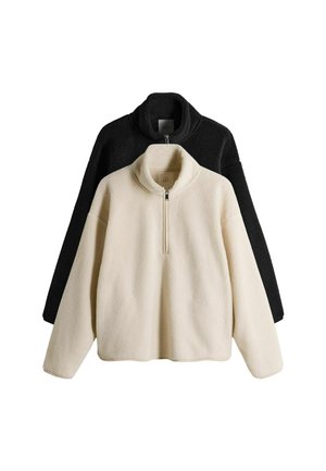 Fleece-Pullover in Schwarz und Creme. Mit hohem Kragen und halber Reißverschluss. Weicher Stoff mit lockerer Passform und überschnittenen Schultern.