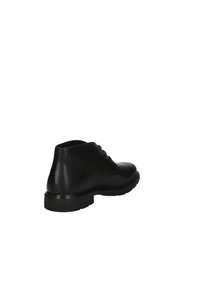 Stivali alla caviglia in pelle nera con una superficie liscia, punta arrotondata, chiusura con lacci sul davanti e suola in gomma robusta con un leggero tacco.
