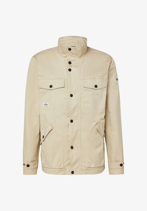 Beige leichte Jacke mit Stehkragen, schwarzen Druckknöpfen vorne, zwei Brusttaschen mit Klappen und zwei unteren Taschen mit Klappen und Knöpfen.