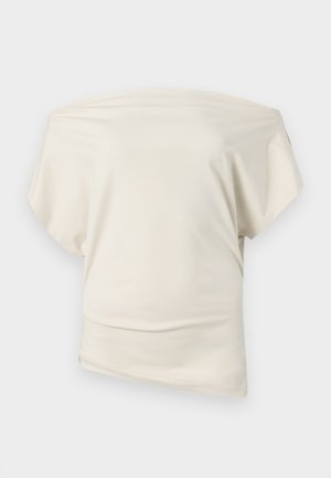 Off-the-shoulder cream top, made of smooth fabric, features a relaxed fit, short sleeves, and asymmetrical hemline.