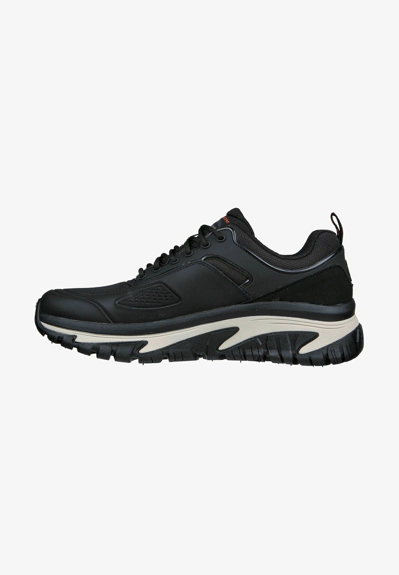 Schwarz sportlicher Schuh mit strukturiertem Obermaterial, Schnürung vorne und gepolsteter Sohle, die einen weißen Akzent entlang der Zwischensohle und ein starkes Profilmuster aufweist.