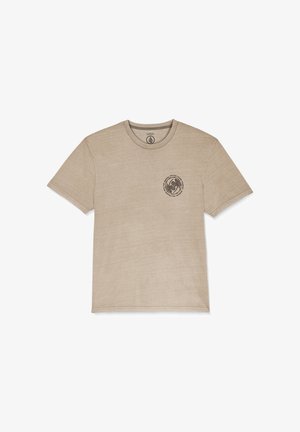 T-shirt in cotone beige con scollo a girocollo classico, maniche corte e un design grafico circolare stampato in marrone scuro sul petto.