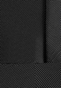 Tessuto nero con una texture a trama, caratterizzato da una superficie liscia e spessori variabili. Il materiale appare durevole e a maglia stretta.