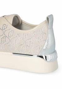 Beige sneaker met zilveren accent, voorzien van een gemarmerde textuur met strass en een glanzende zilveren hiel detail, op een witte rubberen zool.
