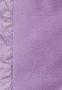 Paarse fleece stof met een zachte textuur, naast een lichter paarse satijnen materiaal. Zichtbare stiksels langs de naad voegen detail toe.