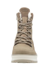 Bota de senderismo beige con un cuello acolchado, parte superior de ante texturizado, ojales metálicos y cordones en contraste. Suela de goma blanca gruesa para tracción.