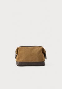 Καφέ υφασμάτινη θήκη με βάση από σκούρο καφέ δέρμα, κλείσιμο με φερμουάρ και πλαϊνές φούντες· απαλή υφή με ανθεκτικό φινίρισμα.