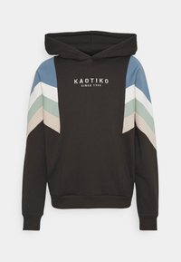 Felpa nera con cappuccio regolabile. Presenta strisce chevron diagonali in blu chiaro, verde e beige. Logo bianco "KAOTIKO" sulla parte anteriore.