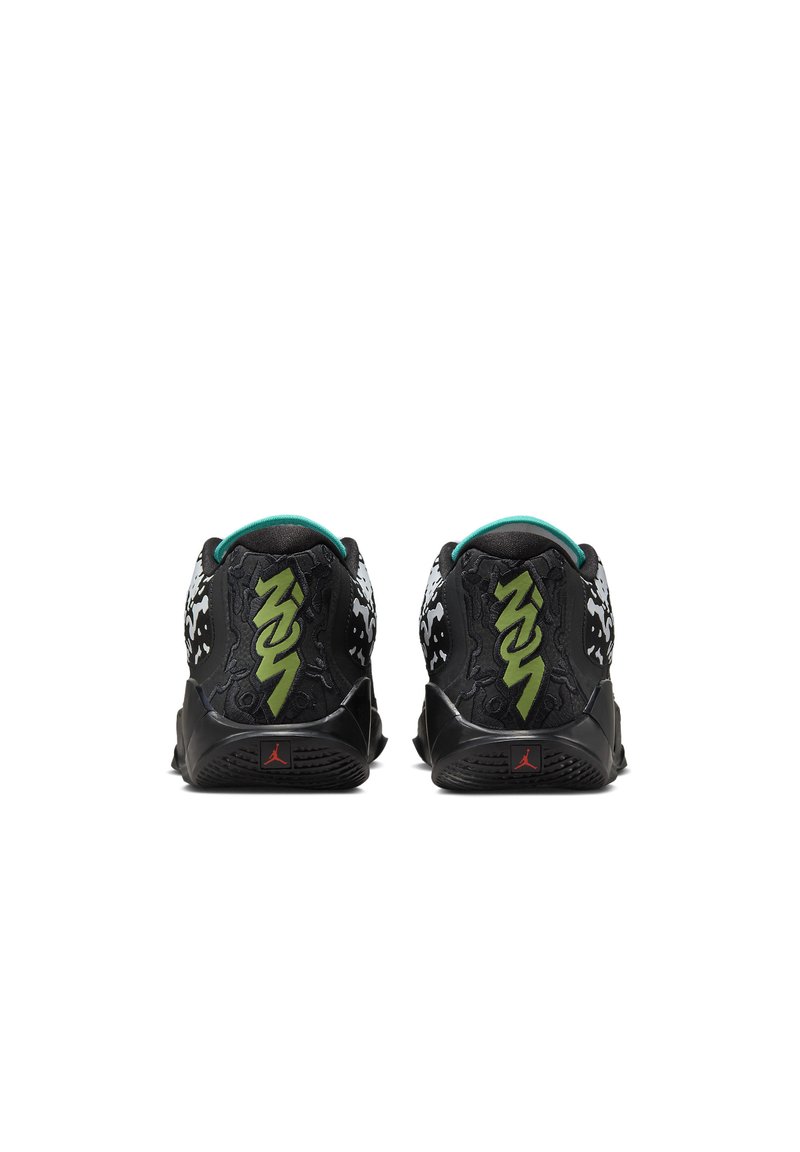 Zapatillas deportivas negras con un upper texturizado, detalles en verde y gráficos blancos audaces en los lados, con un logo rojo en el talón.