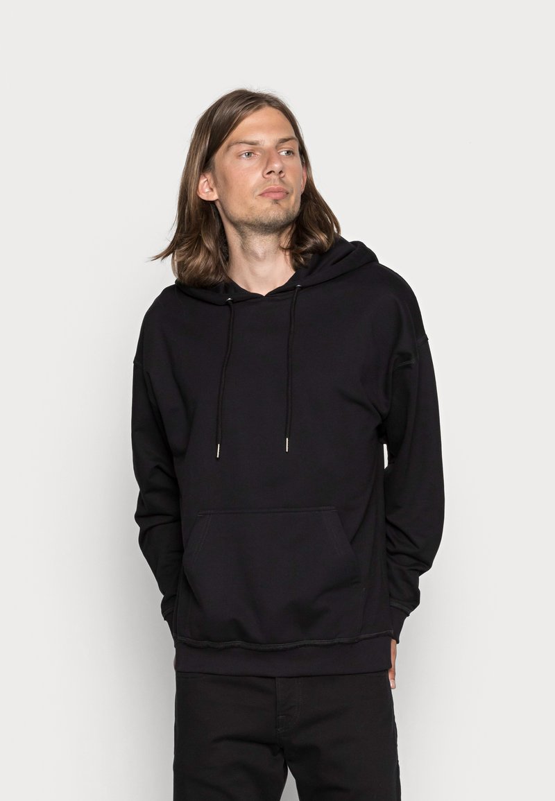Black pullover hoodie made of soft fabric, featuring a front kangaroo pocket, adjustable drawstrings, and ribbed cuffs and hem.