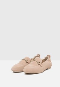 Suede instappers in lichtroze met een platte zool, voorzien van een gouden kettingaccent, een ronde neus en elastische zijpanelen voor gemakkelijke in- en uitloop.
