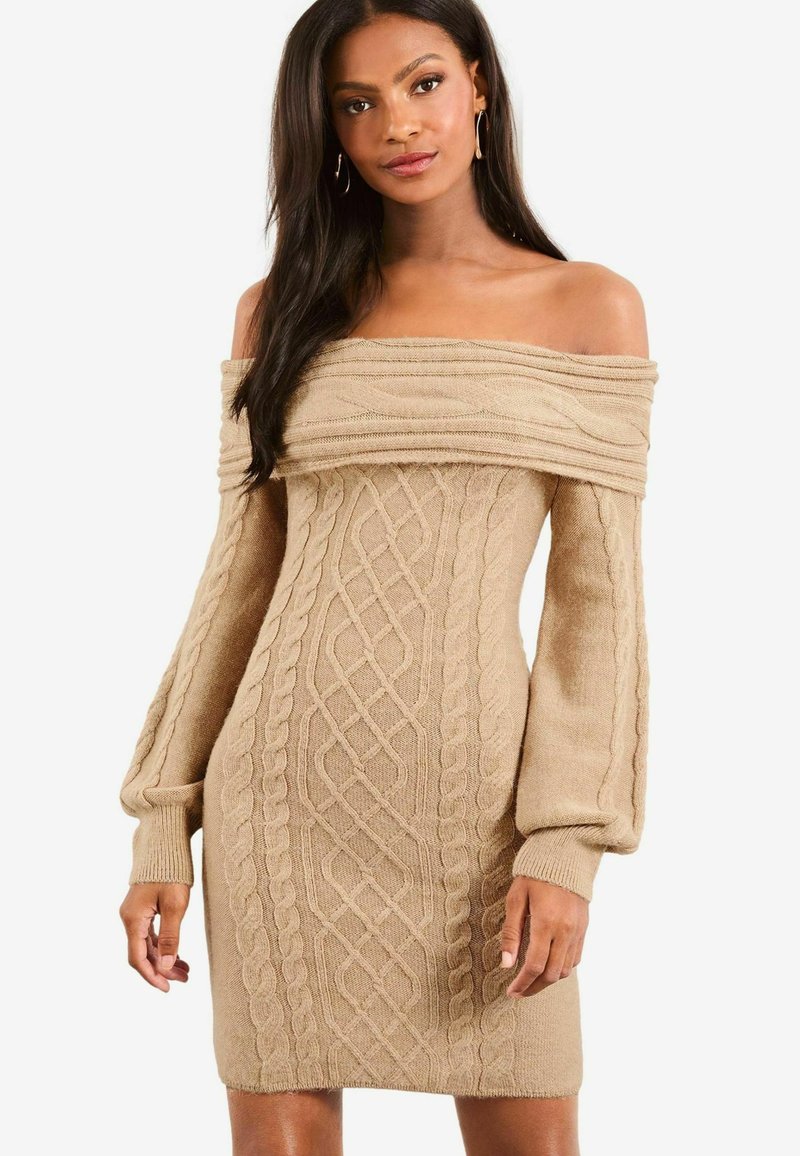 Pletené off-the-shoulder šaty v béžové barvě, s kabelovými vzory, dlouhými nafouklými rukávy a obtaženou siluetou. Měkká textura a elastický materiál.