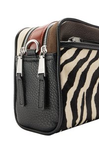 Skórzana torba w wzór zebry z czarnymi teksturowanymi bokami, wyposażona w wiele zamków błyskawicznych oraz kontrastujące brązowe i kremowe panele. Akcenty z srebrnej metaloplastyki.