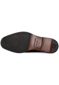 Suola di scarpa in pelle nera con un design curvo e liscio, inserto in gomma e logo impresso. Presenta cuciture visibili e un accento in pelle marrone.