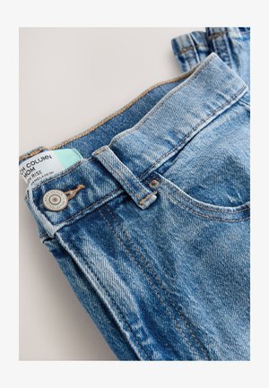Hellblaue High-Rise-Jeans aus Denim mit ausgewaschenem Effekt, ausgestattet mit einem Metallknopf und kontrastierenden Nähten. Tag auf der Innenseite des Bunds sichtbar.