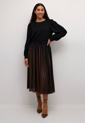Black long-sleeve top with a pleated brown and black skirt. The skirt features vertical stripes and an elastic waistband for comfort.