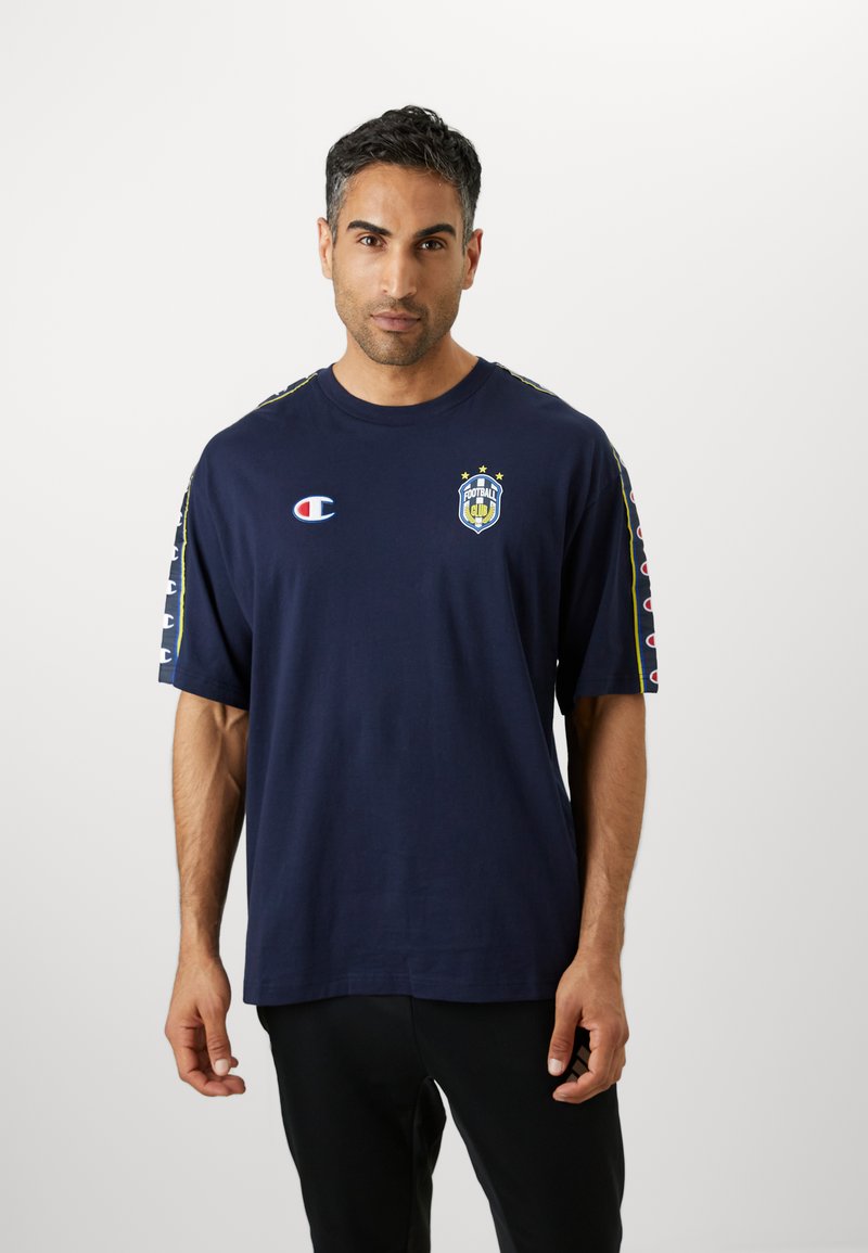 T-shirt à manches courtes marine en coton, avec un logo et trois étoiles. Rayures latérales en couleurs contrastées, col rond, coupe décontractée.