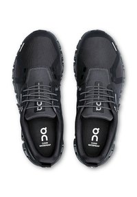 Schwarze wasserdichte Schuhe mit einer strukturierten Oberfläche, stabilen Schnürsenkeln und einem markanten Profil der Sohle. Mit Logo auf den Innensohlen und dem Zehenbereich.