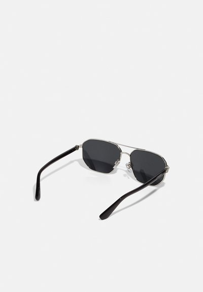 Metāla rāmja saulesbrilles ar astoņstūra lēcām, melnām tonētām lēcām un elegantām melnās plastmasas kājiņām. Funkcijas pulēti akcenti un minimāls aprīkojums.