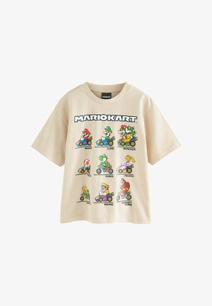 Camiseta beige con estampado gráfico de personajes de Mario Kart en karts coloridos. Mangas cortas y ajuste relajado con cuello redondo.