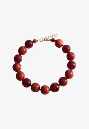 Ronde, gepolijste rode en bruine kralen geregen in een ketting met een verstelbare sluiting met goudkleurige finish op een witte achtergrond.