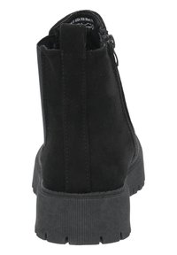 Botines de ante negro con suela de goma texturizada, cierre de cremallera y punta redondeada. Incluyen una pestaña en la parte posterior para facilitar el calzado.
