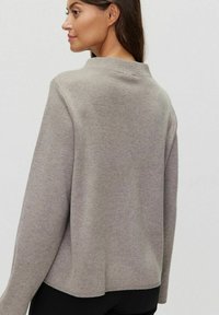 Szary, długosleeve sweter o luźnym kroju, okrągłym dekolcie i prążkowanym wykończeniu. Miękka tekstura i prosty design, widok z boku i z tyłu.