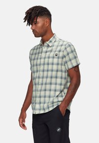 Korte mouwen geruite shirt in lichtgroen en marineblauw. Voorzien van een knoopsluiting aan de voorkant, een kraag en een klein logo patch. Glad katoen stof.