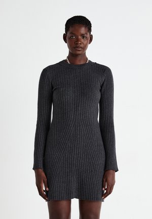 Robe en tricot côtelé gris foncé avec manches longues, col rond et coutures angulaires créant une silhouette ajustée. Tissu texturé avec des lignes verticales.