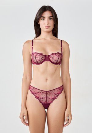 Burgundowy zestaw koronkowej bielizny z delikatnym kwiatowym haftem, przejrzystymi panelami, biustonoszem na fiszbinach oraz pasującym thongiem z falbankami.