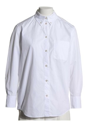 Chemise blanche à manches longues avec boutons et poche poitrine sur un torse de mannequin, avec col boutonné et tissu léger.