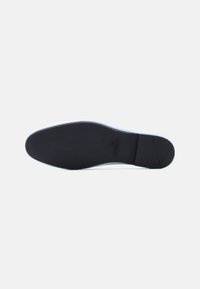 Σόλα μαύρου πλατιού παπουτσιού με λευκή άκρη και ανάγλυφο το λογότυπο "Love Moschino" κοντά στην καμάρα.