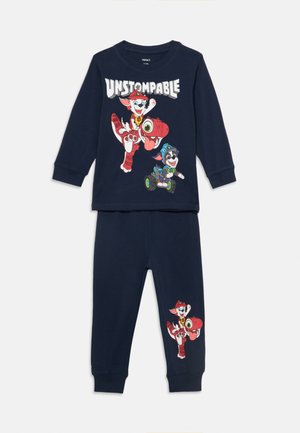 Ensemble haut à manches longues et pantalon bleu marine avec des personnages de chiens dessinés et le texte "UNSTOMPABLE" sur le haut ainsi qu'un motif assorti de chien sur le pantalon.