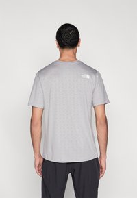 Ανδρικό γκρι μπλουζάκι με κοντά μανίκια, με γεωμετρικό μοτίβο, στρογγυλή λαιμόκοψη και μικρό λογότυπο στο πάνω μέρος της πλάτης.