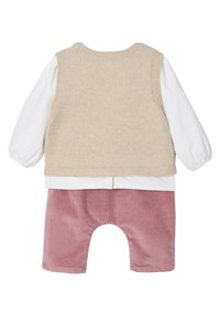 Beige gestrickte Weste über einem weißen Langarmshirt mit elastischen Bündchen und strukturierten rosa Cordshorts, aus weichem und komfortablem Stoff.