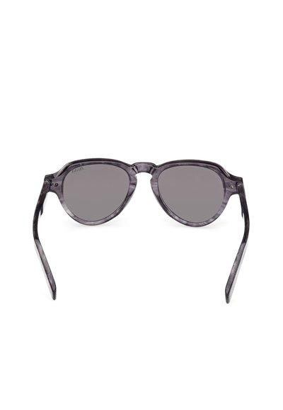 Przezroczyste okulary przeciwsłoneczne w kształcie kociego oka z ciemnoszarymi soczewkami, posiadające przezroczystą szaro-skalną oprawkę, smukłe zauszniki oraz minimalistyczny design.