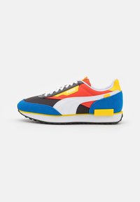 Mehrfarbige Sportschuh mit einer Mischung aus schwarzen, roten, blauen und gelben Materialien. Netz- und Wildledertexturen mit weißen Akzenten und Schnürsenkeln.