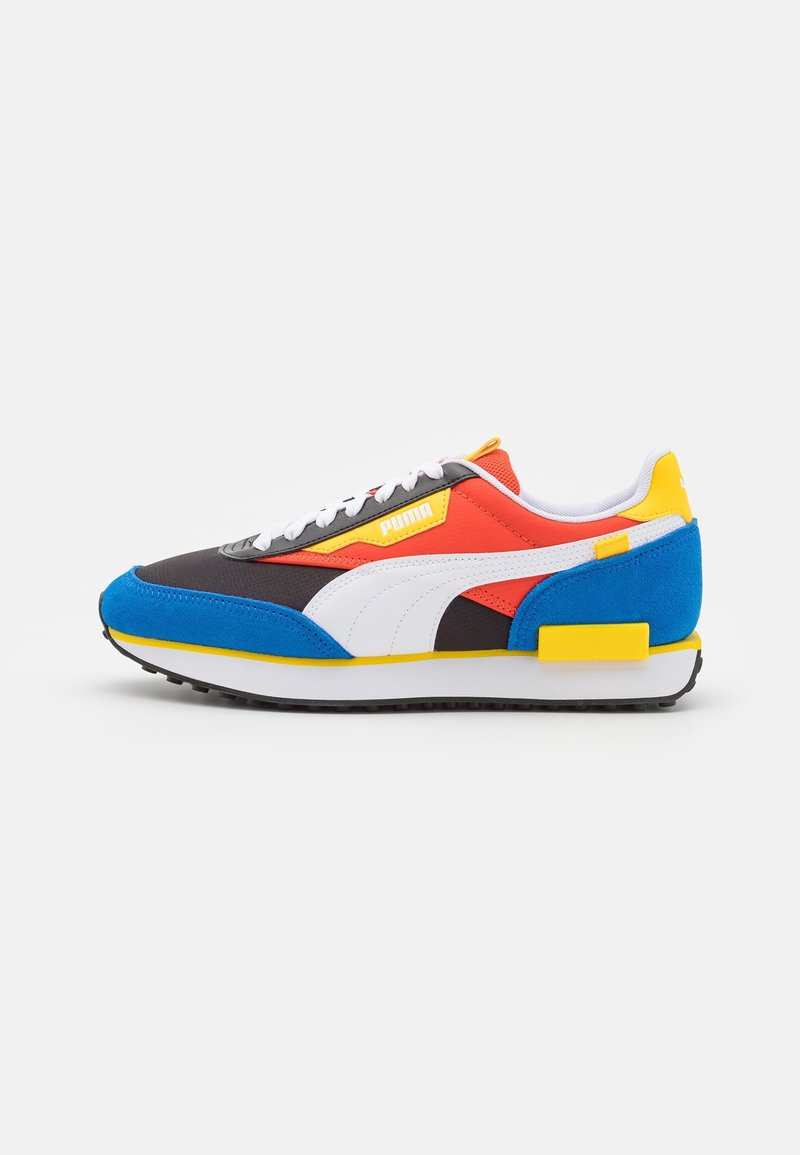 Mehrfarbige Sportschuh mit einer Mischung aus schwarzen, roten, blauen und gelben Materialien. Netz- und Wildledertexturen mit weißen Akzenten und Schnürsenkeln.