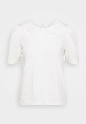 Blusa blanca de manga corta con mangas abullonadas y un cuello Peter Pan con bordado y borde ondulado, cierre con botones en la parte trasera.