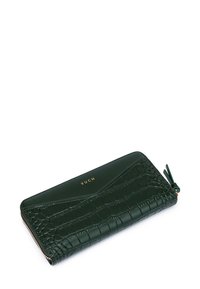 Green leather wallet with a textured crocodile pattern, gold logo on the front, and a zip closure featuring a green tassel accent.