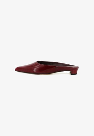 Mule in pelle rossa con punta appuntita, tacco basso e spesso e retro aperto, mostrata di profilo su sfondo bianco.