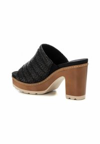 Sandalias abiertas de tiras negras con un chunky tacón de plataforma marrón y suela de goma blanca, con un upper texturizado.