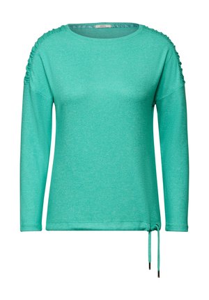 Haut turquoise à manches longues en tissu doux, avec des accents froncés aux épaules et un cordon de serrage réglable à l'ourlet.