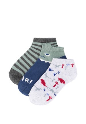 Tres pares de calcetines para niños pequeños hasta el tobillo: uno con rayas grises y verdes, uno azul con la cara de un tiburón y texto "¡RAWR!", y uno blanco con estampados de dinosaurios en rojo y azul.